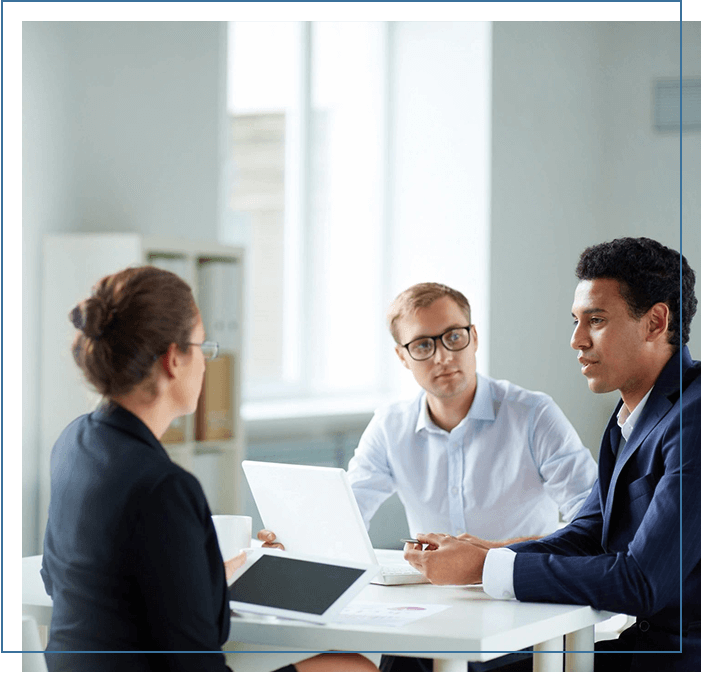 Three people sitting at a table talking to each other.